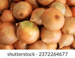 Small photo of top view lot of fresh big yellow onions with peel at the grocery.