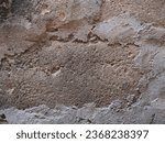 Small photo of Unbalanced cemented wall. Holes on the construction wall. Rough surface of aged wall