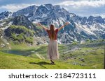 Woman tourist in Mountain lake landscape on Durmitor mountain in Montenegro beautiful Durmitor National park with lake glacier and reflecting mountain Portrait of a disgruntled girl sitting at a