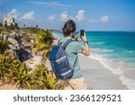 Small photo of Male tourist enjoying the view Pre-Columbian Mayan walled city of Tulum, Quintana Roo, Mexico, North America, Tulum, Mexico. El Castillo - castle the Mayan city of Tulum main temple