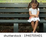 A depressed sad frustrated little girl sitting alone. Social anxiety and stressed children.