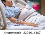 Small photo of A woman in labor, giving birth in the hospital. Childbirth and pregnancy.