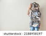 Small photo of Surprised woman holding metal laundry basket with messy clothes on white background. Laundry. Isolated housewife. Copy space. Textile. Dirty wardrobe. Decluttering concept. Disorganized wife.