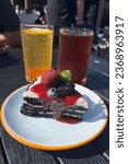 Small photo of Afternoon tea on a terrace, passion fruit tea, berry tea, mulberry, bayberry, blueberry on edible charcoal cake