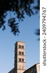 Small photo of A serene bell tower rises elegantly against the blue sky, surrounded by the time-worn ruins of Rome's ancient landscape. It stands as a silent observer, witnessing the unceasing passage of time.