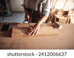 Artisan woman meticulously working on woodcraft in workshop