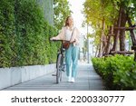Happy Asian young woman walk and ride bicycle in park, street city her smiling using bike of transportation, ECO friendly, People lifestyle concept.
