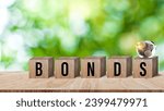 Small photo of Bonds word in wooden blocks with coins stacked in increasing stacks. Bonds increasing concept, investment bond concept Raising Funds to Fund the Green Bond Program