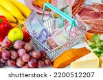 Small photo of Shopping Cart with New Zealand Dollars, Food from the Store Around, New Zealand Food Price Rising Concept, Rising Inflation and Strain on Household Budgets