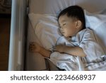 Small photo of An Asian Chinese 1-2 yeas old kid lying on medical bed on bed rest after operation