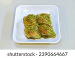 Small photo of Turkish Dessert Sobiyet Baklava, mussels baklava and classic baklava with Pistachio . Cevizli, Fistikli Baklava, top view.