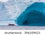 Zodiac in front of enormous ice berg in Antarctica