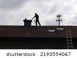 A chimney sweep cleans the...