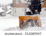 A man removes snow in winter. A man clears snow with a snow cutter