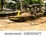 Small photo of Kribi, Cameroon - 20082023: Fishermen after morning fishing pull out boats and unravel nets on the beach on the ocean