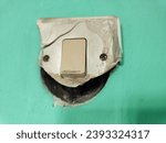 Small photo of the switch is broken, damaged, destroyed, the switch is broken, the light switch is broken, the switch is broken on the wall