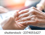 Small photo of Caregiver, carer hand holding elder hand in hospice care background. Philanthropy kindness to disabled old people concept.Happy mother's day.