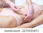 beautician makes lipolytic injections to burn fat on woman's belly and waist. Women's aesthetic cosmetology in a beauty salon. The concept of cosmetology.