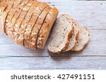 Top view of sliced wholegrain bread on a wooden table.