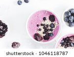 Breakfast with muesli, acai blueberry smoothie, fruits on white background. Healthy food concept. Flat lay, top view, close up