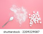 Small photo of Scattered sugar and sugar cubes on a pink background, flat lay.