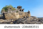 Small photo of Pura Tanah Lot -Bali Indonesia, September 17th 2023: A highly sanctified temple in Bali, temples located on a large rock alongsodeba beatiful beach