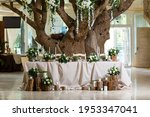 Newlyweds table setting decorated in rustic style. Wedding decor with flowers, candles, succulents, greenery and wooden elements. Nature theme in decoration