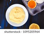 Small photo of Homemade sauce Mayonnaise and ingredients eggs, oil, lemon, mustar on dark blue background. Top view