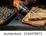 Close up of a metal drill bit set at workshop, carpenter chooses a drill for drilling a wooden block.