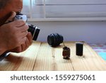 Small photo of man holding and testing manual camera film with color film on wood floor,grain in photo is still a charm of the olden days technology.