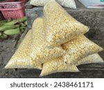 Small photo of the shredded maize is subsequently wrapped in transparent plastic at a dose decided by the dealers. There are two varieties of wrapped corn: white and yellow.selling corns at traditional market