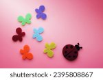 Small photo of artificial wallowed wool ladybug and blue red green yellow orange butterflies on colorful background
