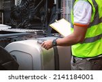 Small photo of Auto Mechanic is Checking the Semi Truck's Fuel Tank Trucks. Diesel Truck. Daily Maintenance Checklist. Lorry Fixing. Truck Inspection Safety Driving.