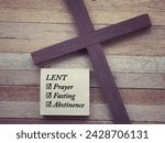 Small photo of Christianity concept about Ash Wednesday, Good Friday, Lent Season and Holy Week. LENT, PRAYER, FASTING and ABSTINENCE written on a paper. With blurred style background.