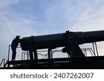 Small photo of Whidbey Island, WA USA November 20 2018: unidentified man silhouette looking at gunnery cannon at Fort Casey on Whidbey Island in Washington state.