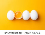 White eggs and egg yolk on the yellow background.