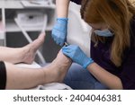 Small photo of Shortening of toenails at a professional beautician's salon.