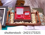 Small photo of 08 October 2009 Cirebon Indonesia. The groom's wedding dowry consists of a pair of gold rings and bracelets placed in a neat container and decorated with a garland of jasmine flowers.