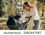 Young mother walking with baby stroller