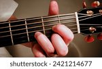 Small photo of a picture of a hand making a D Chord on a guitar fret board. This photograph shows an up close view of the correct hand position for making the D chord.