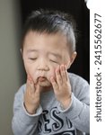 Small photo of A child's face reflects despair, disbelief and a plea for cessation. Asian boy's face reflects disbelief and saying "That's enough, please stop" inside his head.