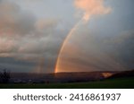 Small photo of Double rainbow wheel with crepuscular rays pictured at evening after a shower
