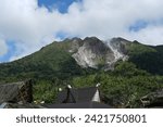 Small photo of This is a traditional house Karo north sumatra indonesia with a backdrop of Mount Sibayak