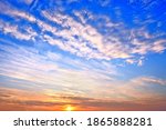 cold sunset sky on winter evening landscape background. Wide panorama cloudscape. Scenic sky with setting sun behind clouds. Nature abstract wallpaper
