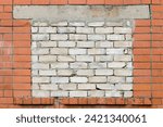 Old aged weathered red brick wall background bricked-up window aperture bricked-in white silicate bricks grungy textured large horizontal dirty pattern copy space closeup broken windows theory concept