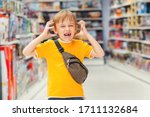 Small photo of ?hildren's tantrum in the store. Boy can't selecting toy in kids store. Many toys around. Shop toys.Inside toy shop. Little boy getting hysterical in toy shop.Kid makes difficult choice in supermarke