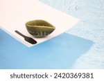 Small photo of A small bowl as a boat beside with a small spatula riding along the large oceans that imply a solitude at sea of a tiny boat in vast waters.