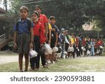 Small photo of Guwahati, India. 16 Nonember 2023. Students walk in line holding plastic bags to submit them as school fees at the Akshar Forum school in Pamohi in the outskirt of Guwahati.