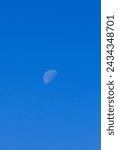 Small photo of Waning gibbous moon in a blue sky during daytime