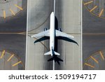 Aerial view of narrow body aircraft departing airport runway.